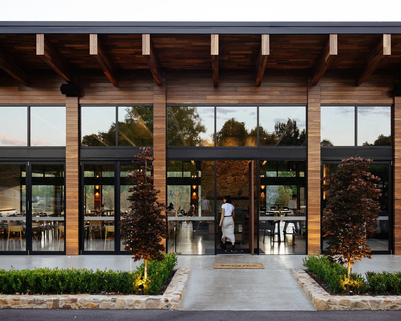 Precision glazed bi-fold doors and architectural facade at dusk